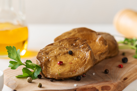 Aufgeschnittener Seitan auf einem Küchenbrett.